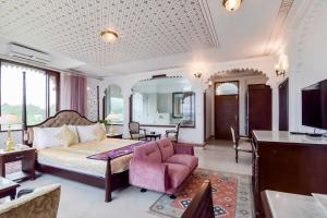 a bedroom with a bed and a living room at Hotel Raj Kuber in Udaipur