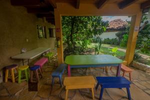 ein Zimmer mit bunten Tischen und Hockern auf einer Terrasse in der Unterkunft Rossco Hostel & Hotel in San Cristóbal de las Casas