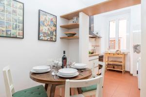 Una cocina y un comedor con mesa y sillas de madera. en Casa dell'Arco - WelcomeToRhome, en Roma