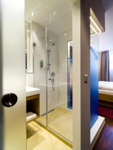 a bathroom with a shower with a glass door at Hotel Asemann Planegg in Planegg