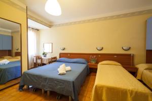 a bedroom with two beds and a mirror at Hotel Ricordo Du Parc in Tabiano