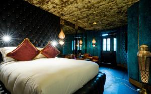 
a large bed in a room with a large window at Crazy Bear Beaconsfield in Beaconsfield
