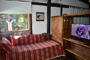 sala de estar con sofá y TV en Cabañas Rio Mendoza en Cacheuta