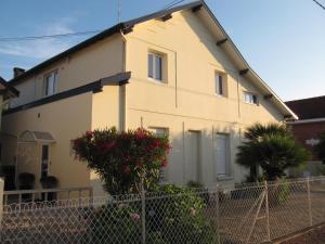 a white house with a fence in front of it at Hôtel L'Arbousier in Soulac-sur-Mer