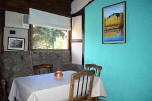 comedor con mesa y ventana en Cabañas Rio Mendoza en Cacheuta