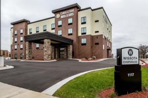 a hotel building with a sign in front of it at Cobblestone Hotel & Suites - Stevens Point in Stevens Point