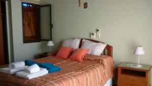 een slaapkamer met een bed met handdoeken en een spiegel bij Chalets Andalgala in Merlo