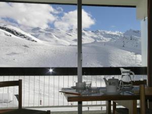ヴァル・トランスにあるClubHotel le Gypaete Residence Val Thorensの窓越しに雪山を望む