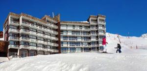 ヴァル・トランスにあるClubHotel le Gypaete Residence Val Thorensのホテル前の雪の中でのスキー2名分