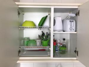 a kitchen pantry with green dishes and utensils at Bamboli Holidays in Playa de las Americas