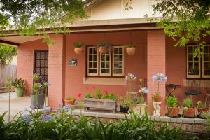 a pink house with potted plants in front of it at Taree Apartment in Taree