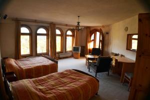 a bedroom with two beds and a desk with a computer at Family Hotel Silver in Smolyan