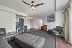 - un salon avec un canapé et un ventilateur de plafond dans l'établissement El Motor Inn, à Port Macquarie