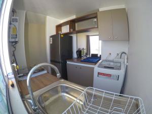 a small kitchen with a sink and a refrigerator at Departamento La Serena in La Serena