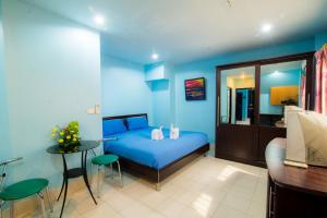 a blue bedroom with a bed and a table at DE Apartment in Pattaya South