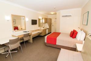 Dubbo RSL Club Motel في دوبو: غرفة في الفندق مع سرير ومكتب