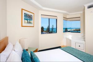 a bedroom with a bed and a window at BreakFree Grand Pacific in Caloundra