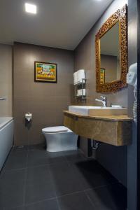 a bathroom with a sink and a toilet and a mirror at Aiyara Palace in Pattaya North