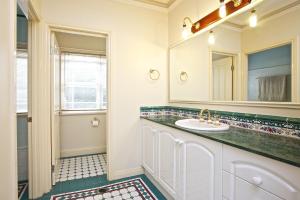 bagno con lavandino e specchio di Tranquil Garden Hideaway a Ormeau