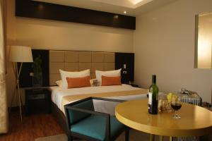 a bedroom with a bed and a table with a bottle of wine at Hotel Oazis in Butuan
