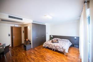 a bedroom with a bed and a wooden floor at Draconerium Hotel in Dronero