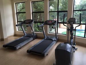 eine Reihe von Laufbändern in einem Fitnessraum mit Fenstern in der Unterkunft Casa ozone in Nairobi
