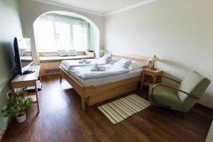 a bedroom with a bed and a desk and a chair at Hotel Panský dům in Nové Město na Moravě