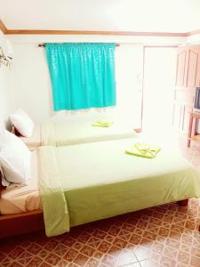 Un pat sau paturi într-o cameră la Rayong Phurua Resort
