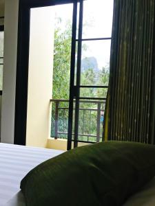a bedroom with a large window and a bed with a pillow at T.P. Place Hotel in Phangnga