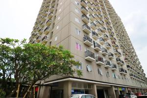 a tall building with cars parked in front of it at Adaru Property at Sunter Park View in Jakarta