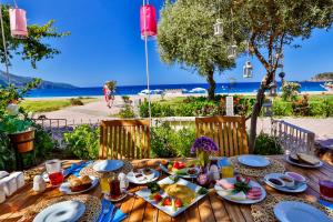 a wooden table with food on it with a view of the ocean at Oyster Residences - Adult Only in Oludeniz