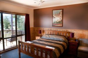 ein Schlafzimmer mit einem Bett und einem Balkon in der Unterkunft Whistler in Bright