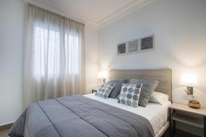 a bedroom with a large bed and a window at Flatsforyou Cabanyal Beach in Valencia