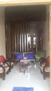 a living room with a blue couch and chairs at Homestay Syariah Grahadi in Malang