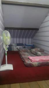 a room with a bed and a fan in a room at Homestay Syariah Grahadi in Malang
