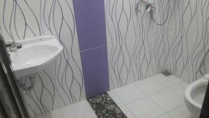 y baño con lavabo y aseo. en Homestay Syariah Grahadi, en Malang