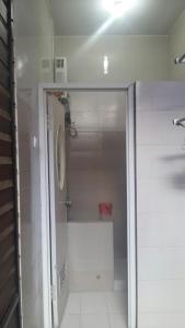 a bathroom with a shower with a glass door at Homestay Syariah Grahadi in Malang