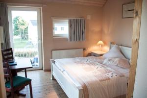 Schlafzimmer mit einem Bett, einem Tisch und einem Fenster in der Unterkunft Havneby Kro in Havneby