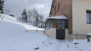 un edificio con nieve en el suelo junto a una casa en Gite de L'ours, en La Bresse 33 fotos más