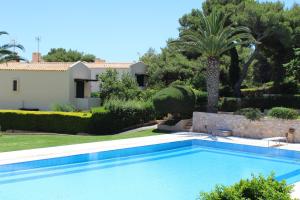 a swimming pool in front of a villa at Pasha Bay Residence in Sounio