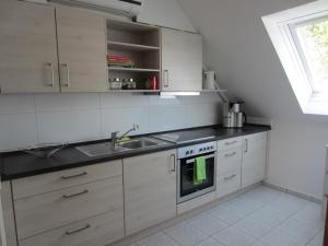 a white kitchen with a sink and a stove at Appartement Munz in Kirchheim unter Teck