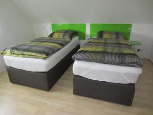 キルヒハイム・ウンター・テックにあるAppartement Munzのベッド2台が隣同士に設置された部屋です。
