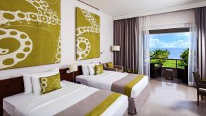 a hotel room with two beds and a balcony at Amaya Beach Passikudah in Pasikuda