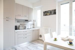Mi Suzzani في ميلانو: مطبخ بدولاب بيضاء وطاولة بيضاء
