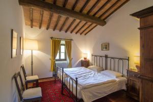 a bedroom with a bed and a chair and a window at Podere Sagna in Castellina in Chianti