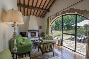 a living room with a fireplace and a green couch at Podere Sagna in Castellina in Chianti