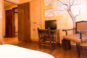 a bedroom with a desk with a television and a chair at Santa Ana B&B in Darnius