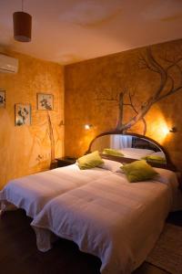 a bedroom with a large bed with a tree mural on the wall at Santa Ana B&B in Darnius