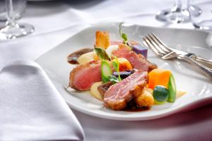 un plato de comida con carne y verduras en una mesa en Landgoed De Holtweijde en Lattrop