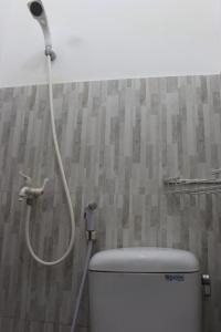 a shower in a bathroom with a toilet at Rumah Pathuk Syariah Homestay in Yogyakarta